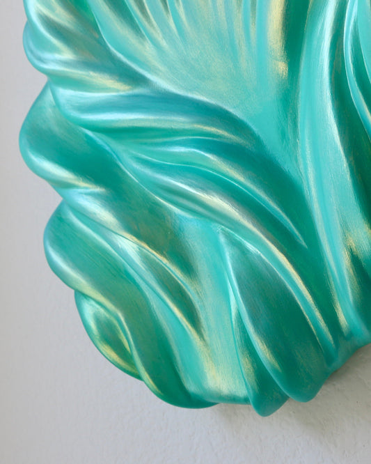 Turquoise decorative wall piece on a plain white background