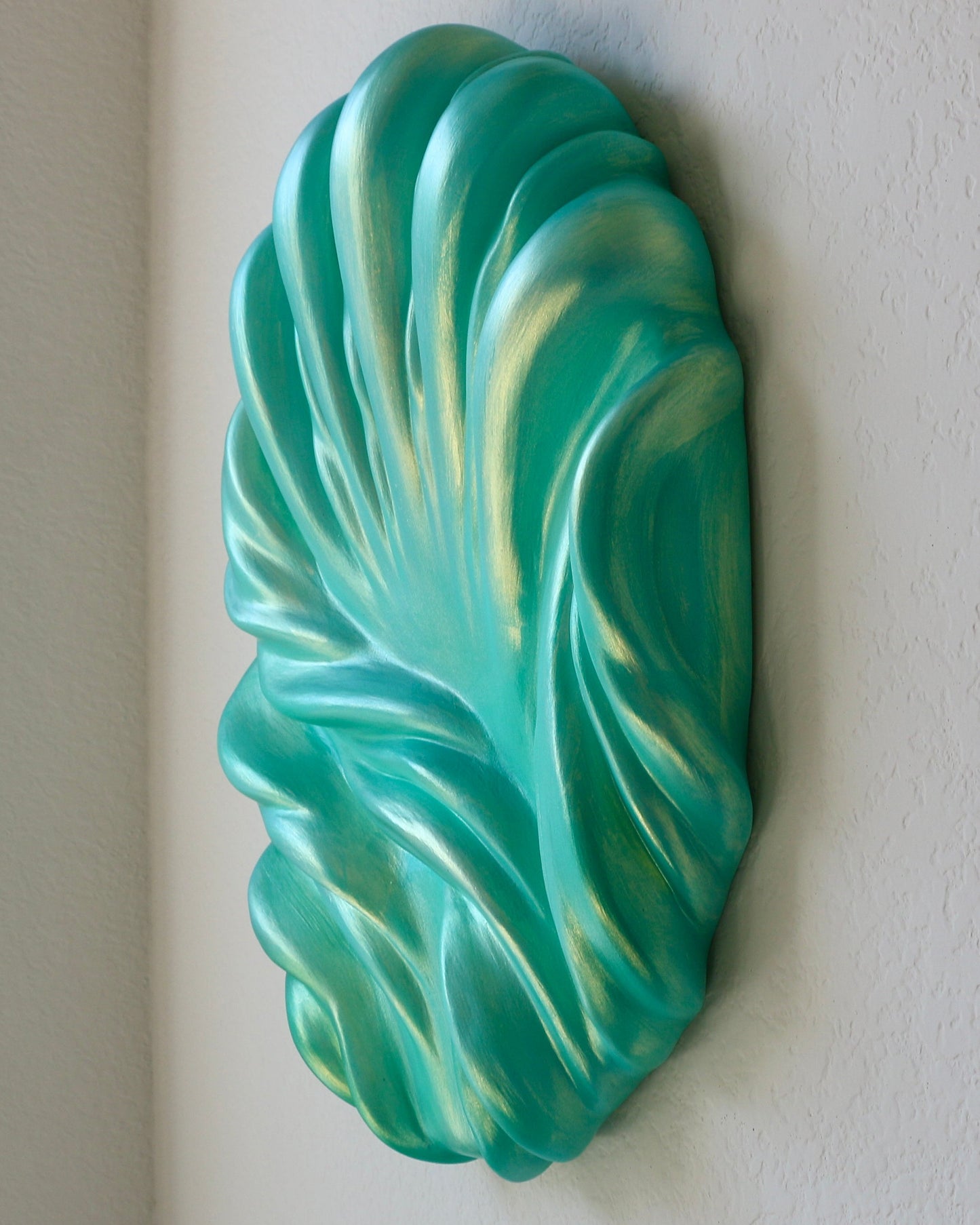 Decorative green wall sculpture on a plain background